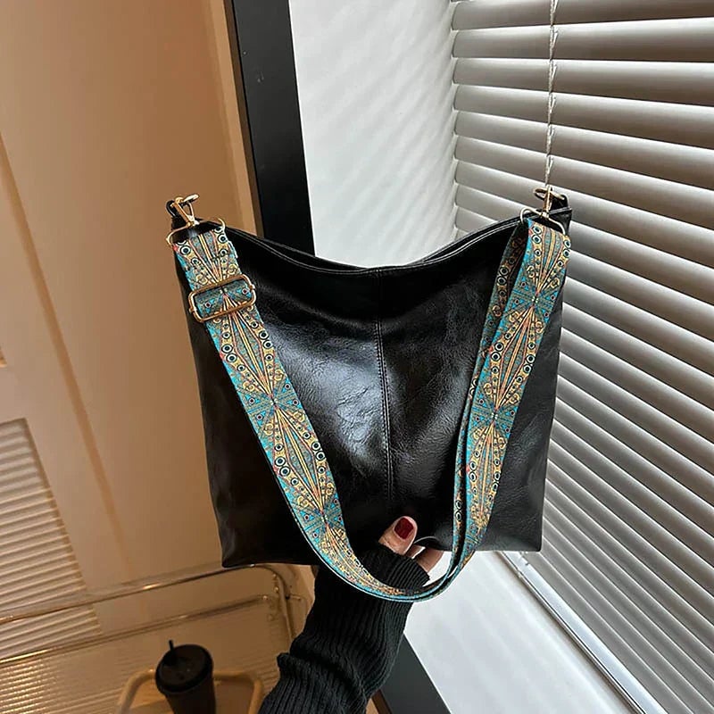 Black fashion bag with gold-tone hardware detail, close-up