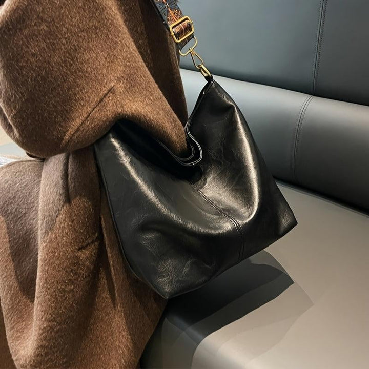 Green fashion shoulder bag against neutral background, front view