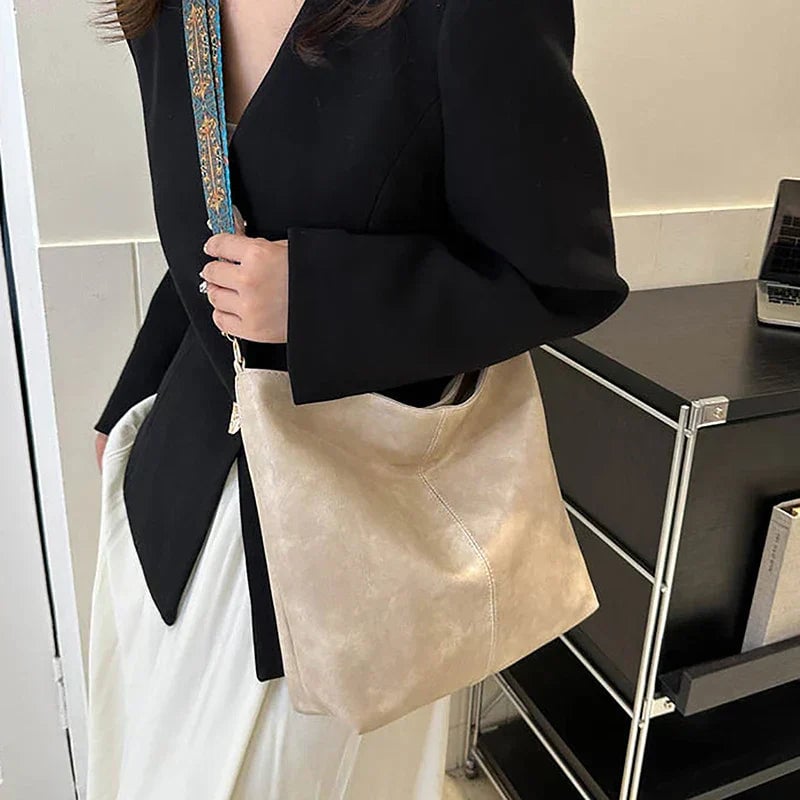 Black shoulder bag with patterned strap, angled view