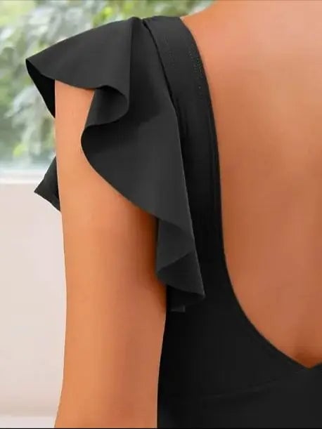 Full-length shot of the one-piece swimsuit in white with criss-cross neckline and cut-out sides