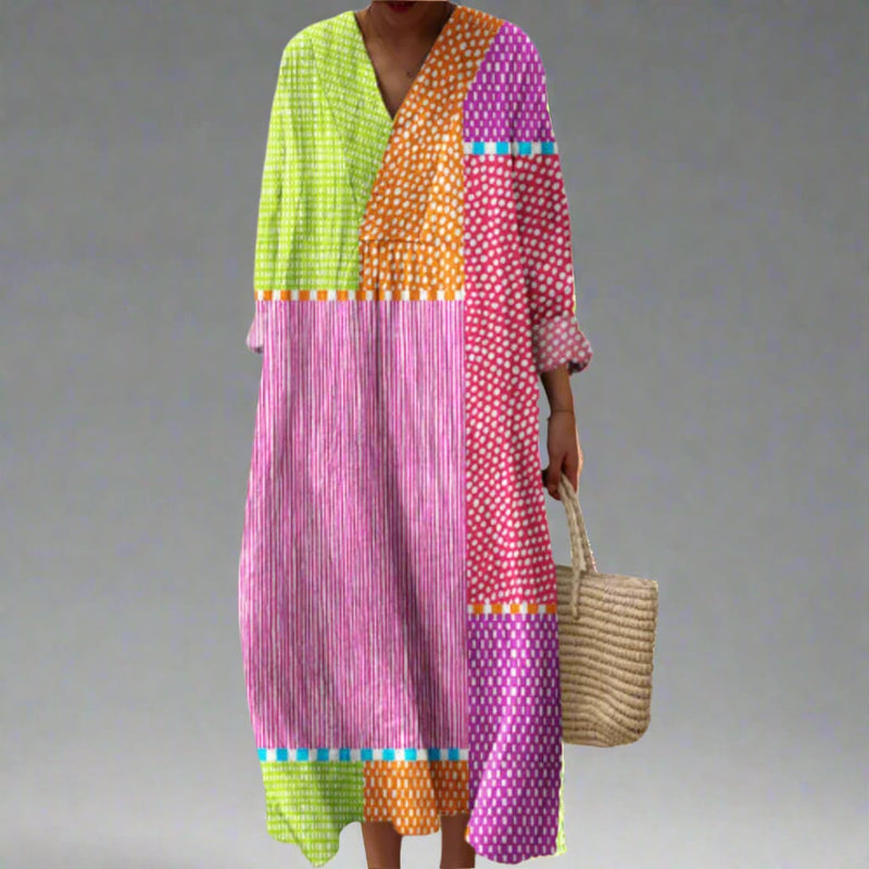 Woman wearing an elegant flowing dress with a bold abstract geometric print in a relaxed flattering silhouette