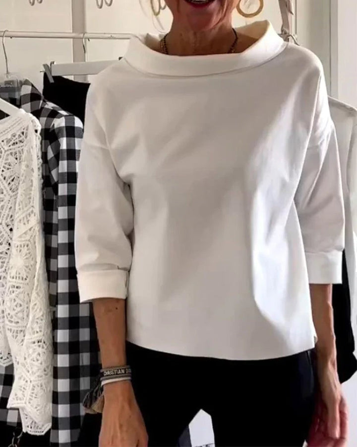Woman wearing a blue relaxed-fit 3/4 sleeve bateau neck top, front view