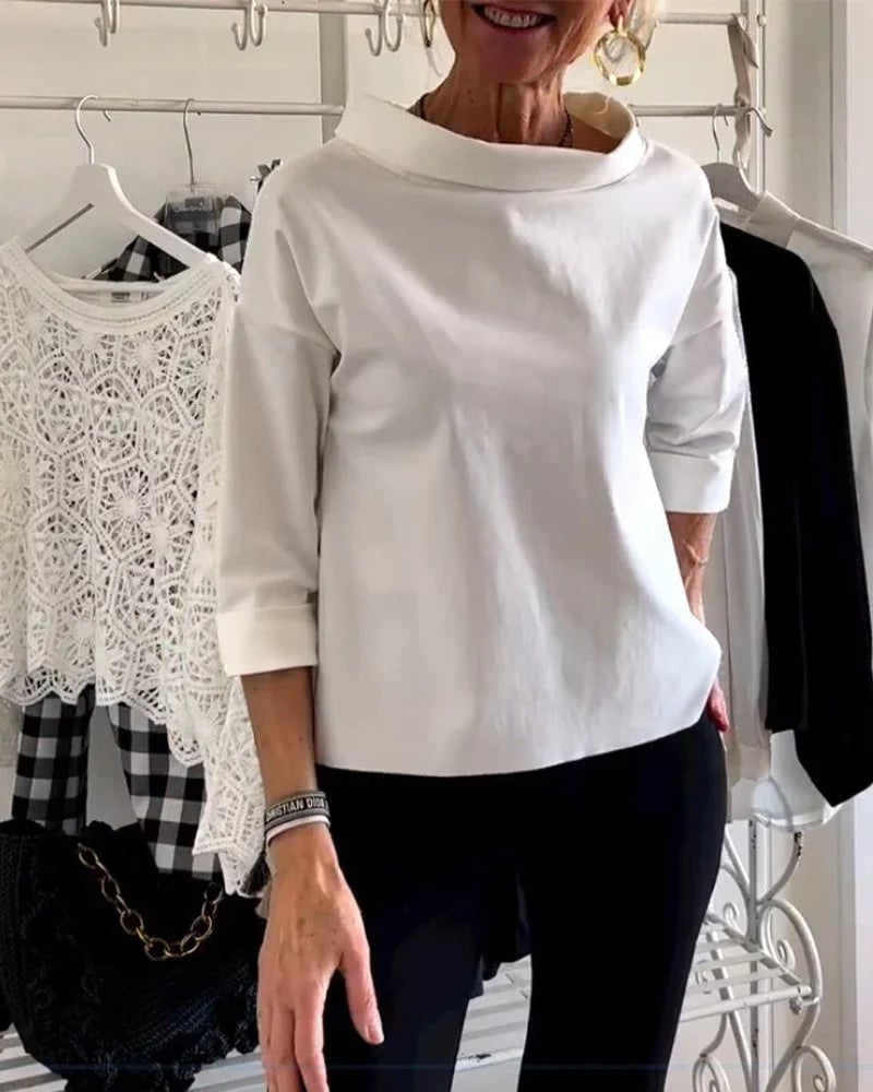 Woman wearing a black drop-shoulder bateau neck casual top, front view