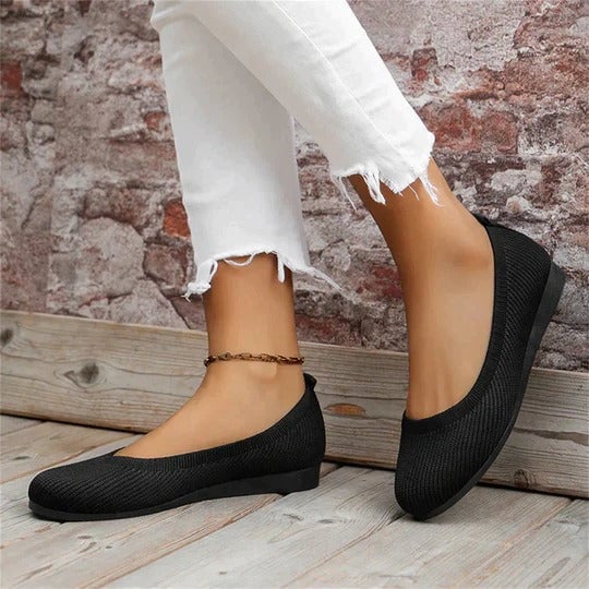 Pair of Maya knit slip-on flats in red styled with cropped jeans on a lifestyle background