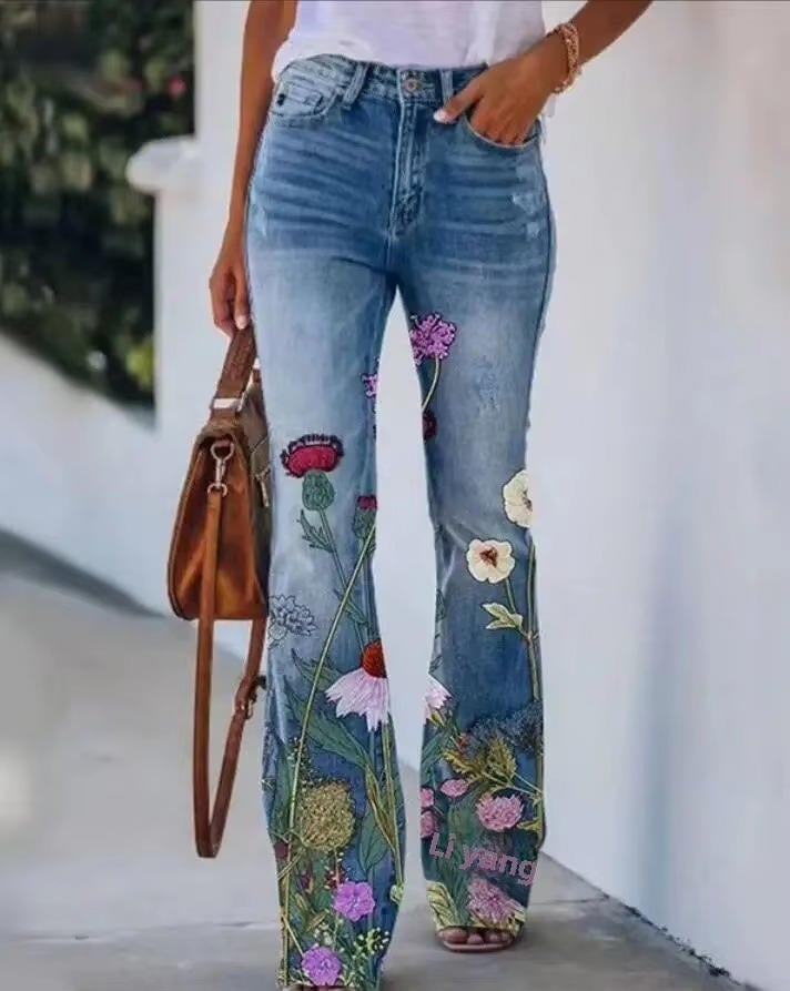 Close-up of vibrant garden-inspired floral print on the flared hem of blue denim jeans