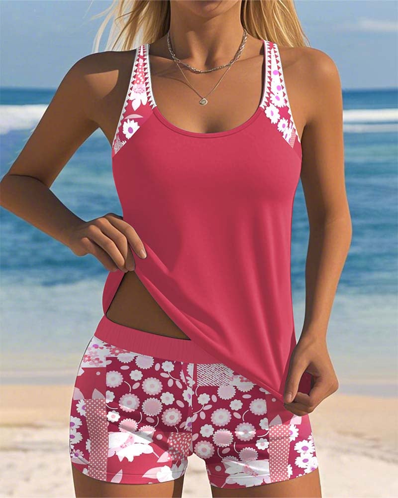 Model wearing a pink floral two-piece tankini set with tank top and matching shorts at the beach