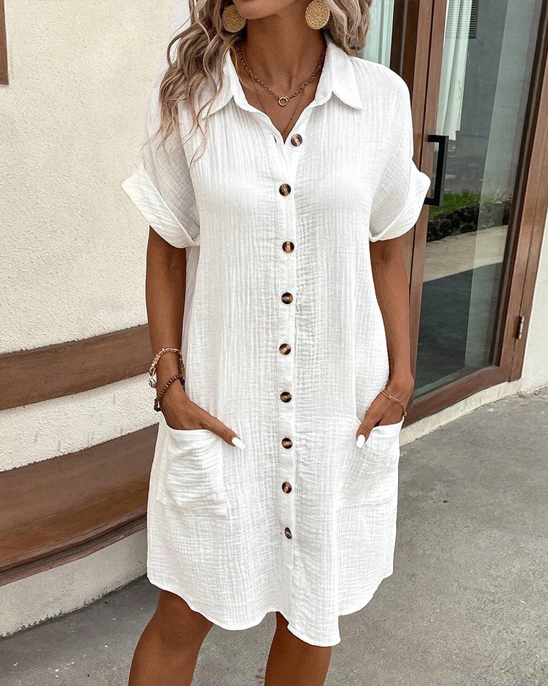 Woman wearing a loose, flowing white summer dress with a light and airy silhouette