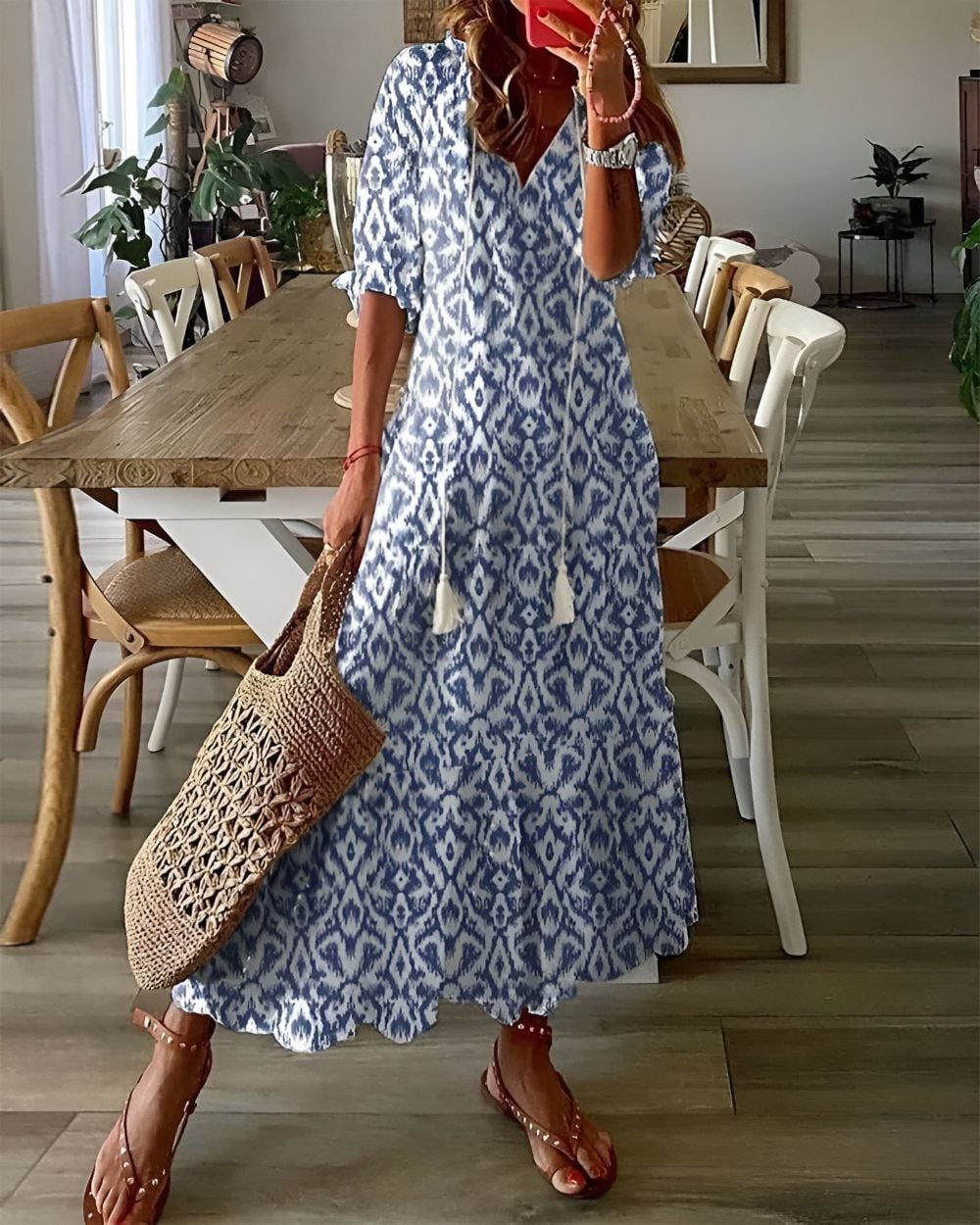 Woman wearing a flowy blue boho covering dress with tassel details on a sunny day