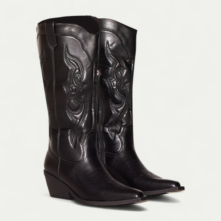 Woman wearing black calf-high western pointed toe boots styled with slim jeans