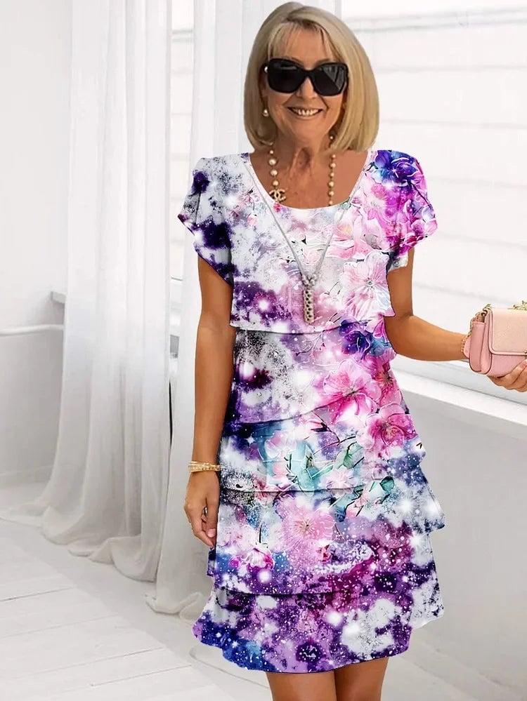 Model in a pink ruffled floral pleated dress styled for a garden party occasion