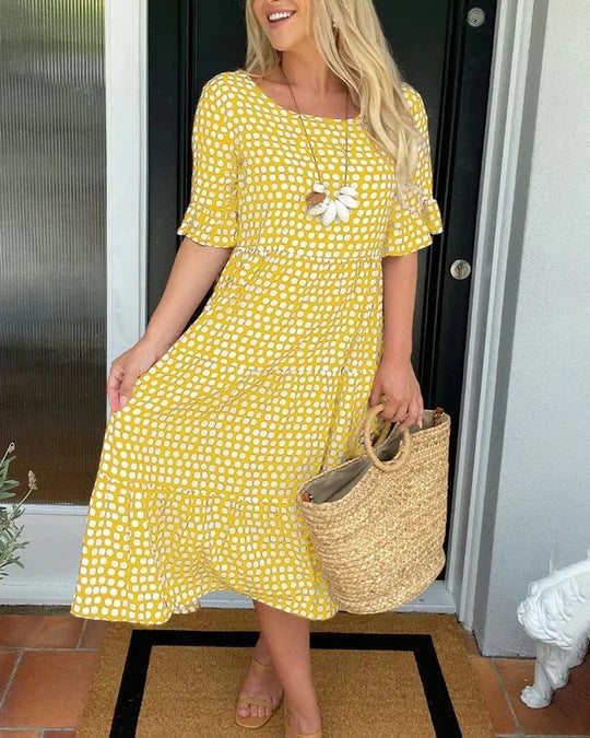 Front view of a flowy dotted midi dress showing the tiered silhouette and lightweight fabric