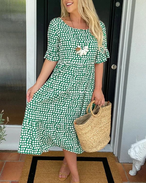 Model wearing the dotted midi dress in red, paired with wedge sandals outdoors
