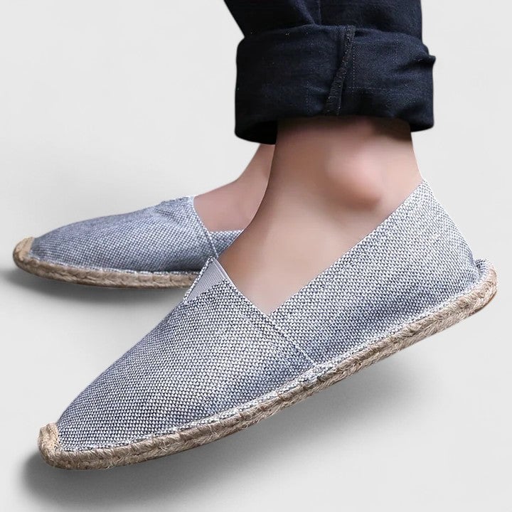 Lifestyle shot of Mila white slip-on espadrille flats styled with linen trousers