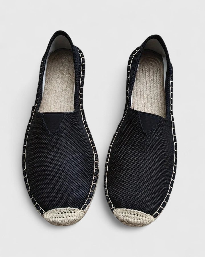 Mila espadrille flats in all five colors — white, beige, black, brown, and grey — arranged in a flat lay