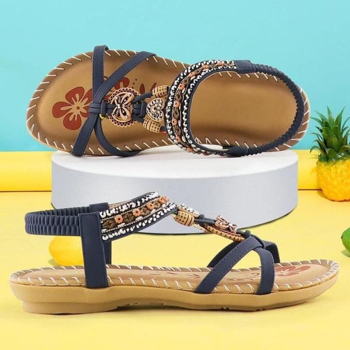 Millicent women's sandals in blue with stretchable elastic bands, top-down flat lay on neutral background