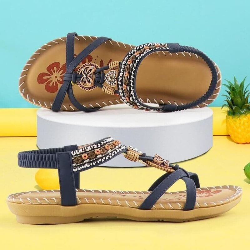Millicent women's sandals in blue with stretchable elastic bands, top-down flat lay on neutral background