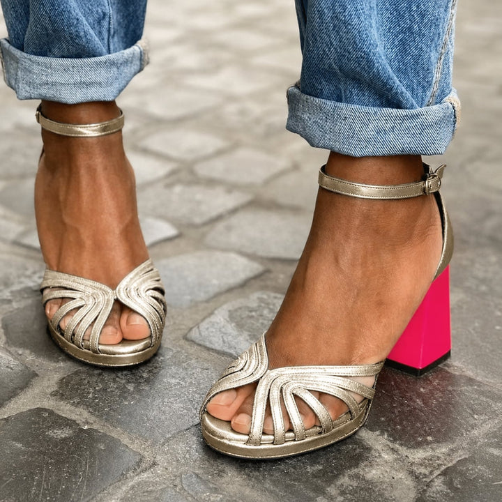 Gold open-toe block heel sandal with ankle strap, front view on white background