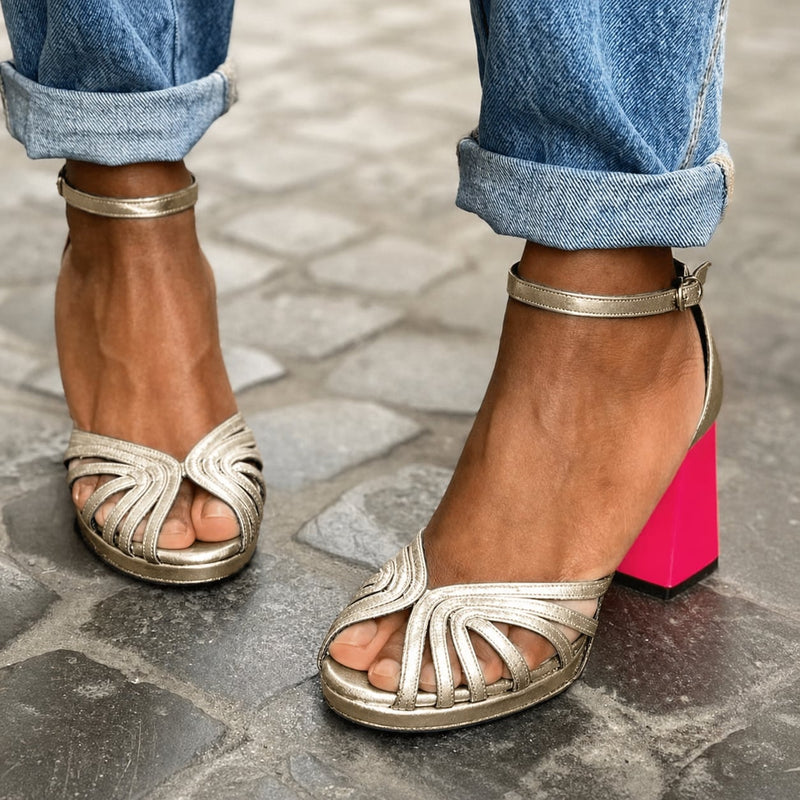 Gold open-toe block heel sandal with ankle strap, front view on white background