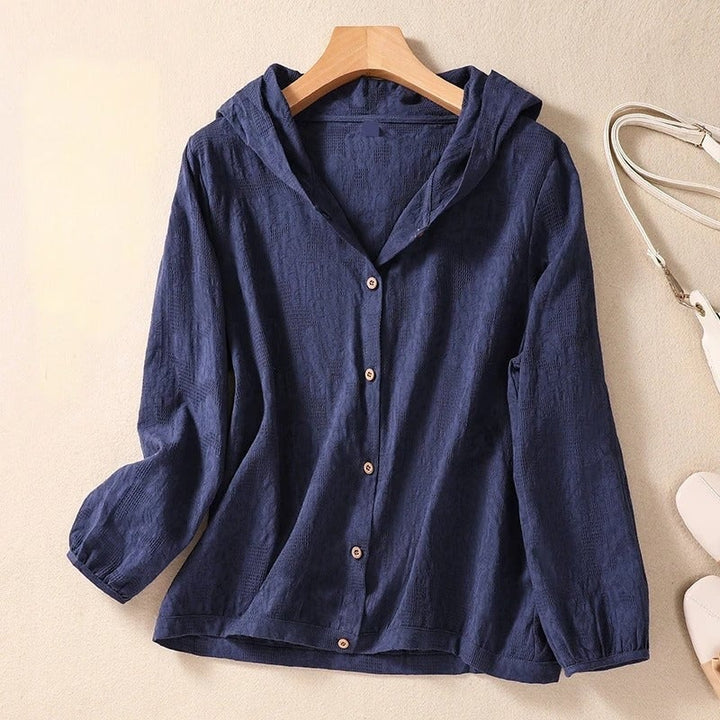 Flat lay of the hooded shirt in three color options: white, pink, and navy blue