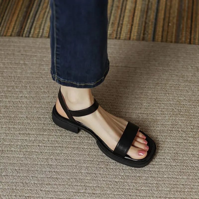 Molly sandal in black styled with a flowy midi dress on a woman walking outdoors