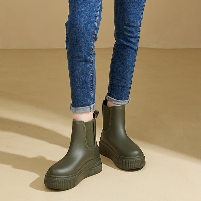 Mona green rain boots shown from the front on a neutral surface
