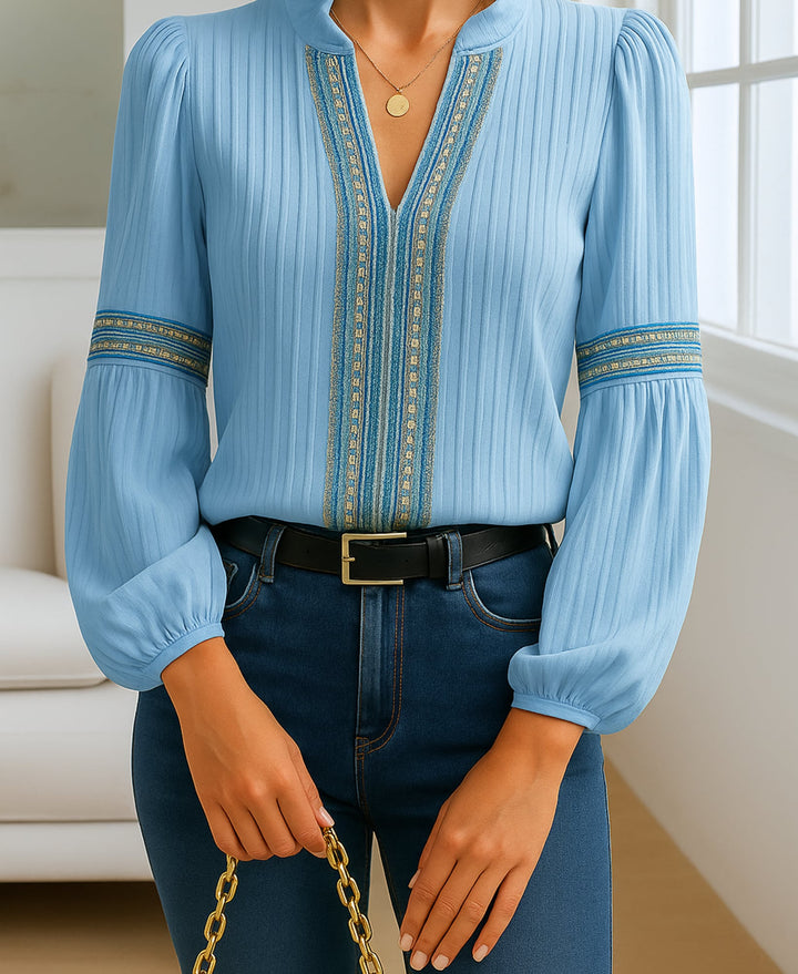 Flat lay of a cream embroidered V-neck blouse highlighting the lightweight fabric