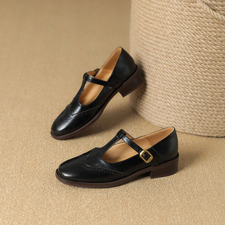 Nadine black leather Mary Jane shoes, side profile showing T-bar strap and gold-tone buckle
