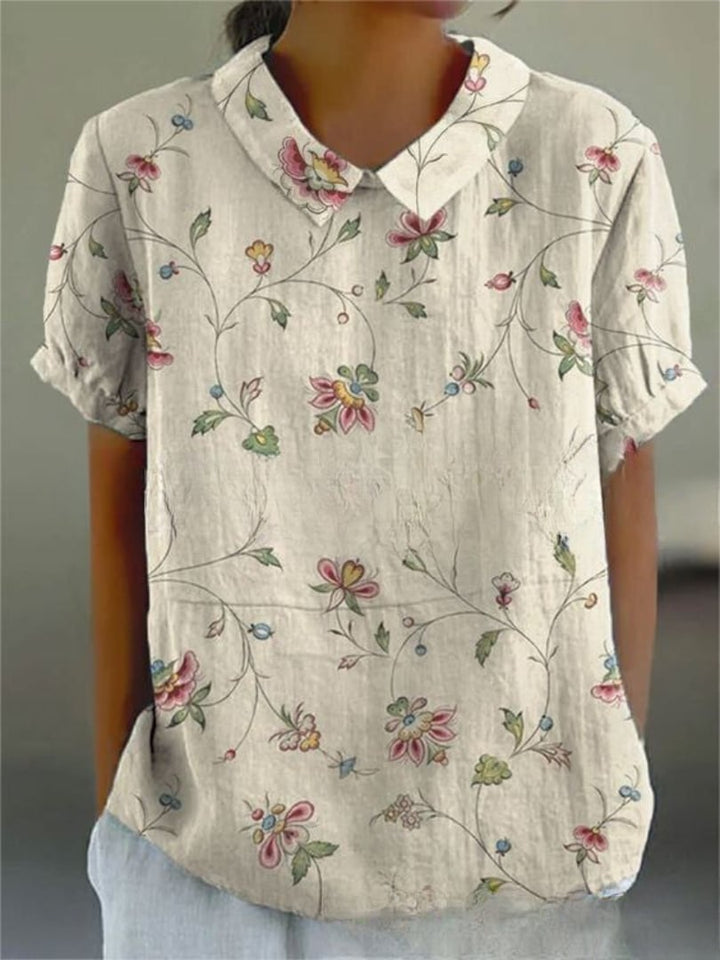 Front view of the Nancy floral shirt in white with flowers, featuring a loose, flattering silhouette
