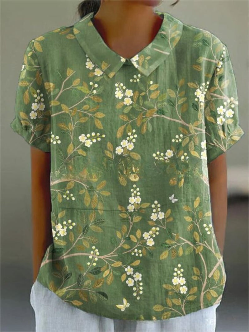 Model wearing the Nancy floral shirt in light pink floral print, paired with casual bottoms