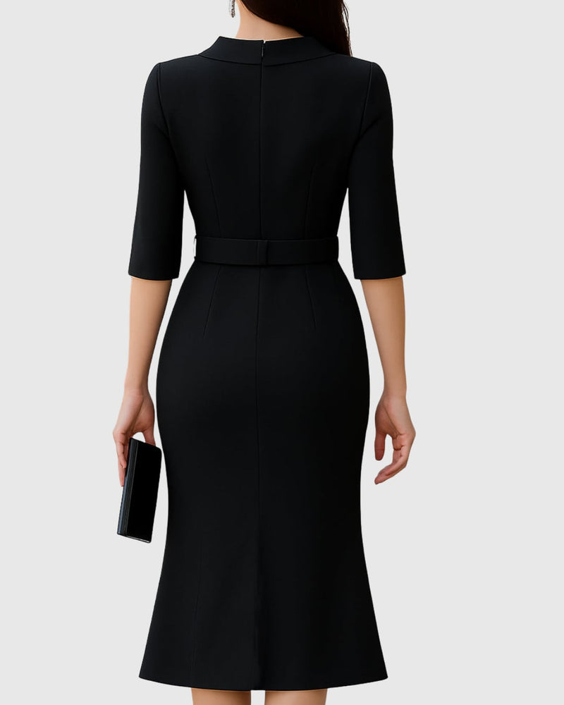 Close-up of the wide silver-buckle belt and folded mock neck collar on a black midi dress