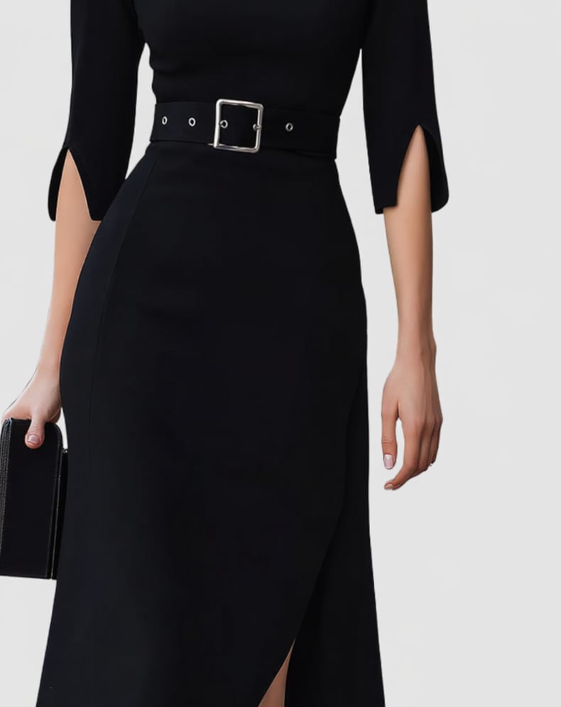 Back view of a woman in a black belted midi dress showing the asymmetric hem and split sleeve detail