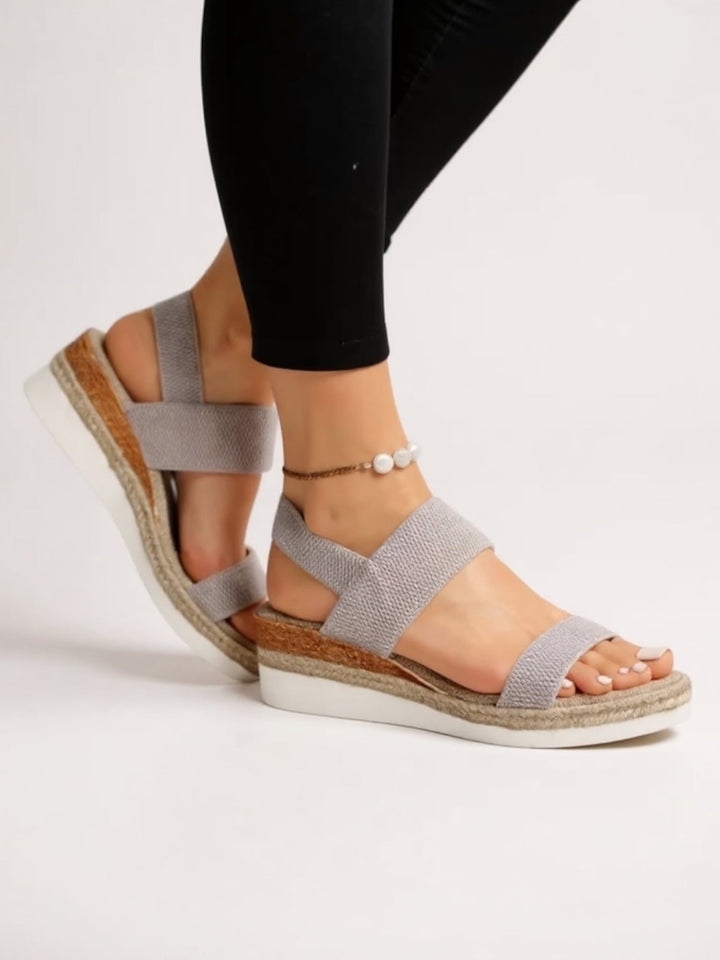 Back view of Neve platform sandals in black worn by a model showing heel strap detail