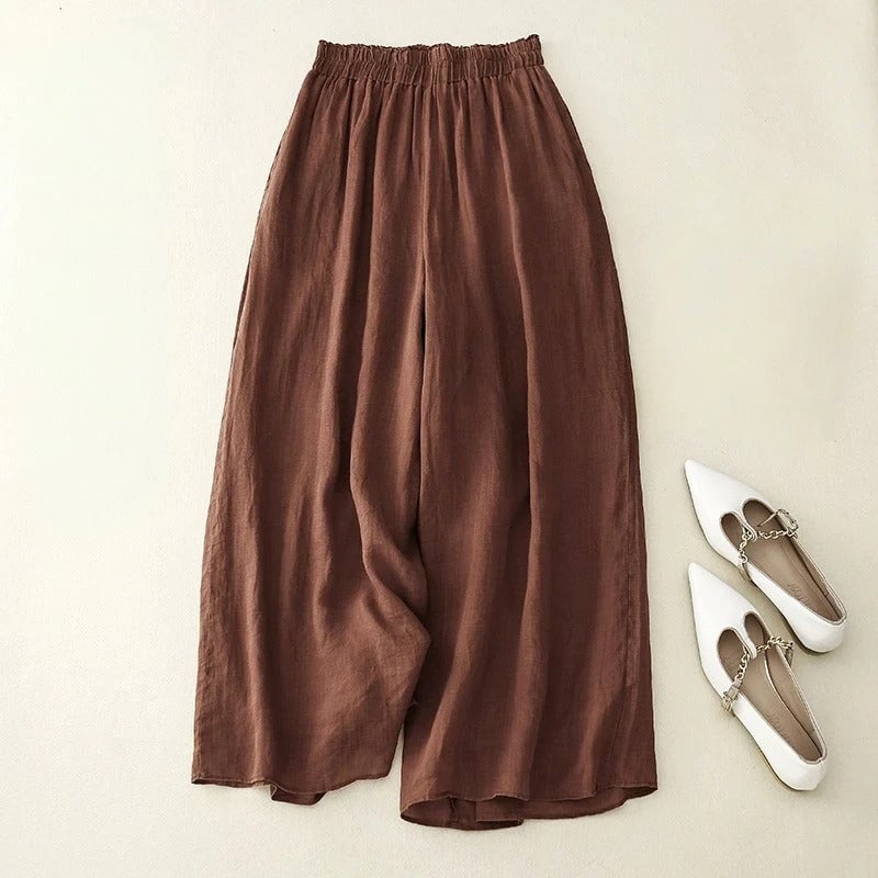 Woman wearing elegant loose waistband wide-leg pants in a neutral colorway, full front view