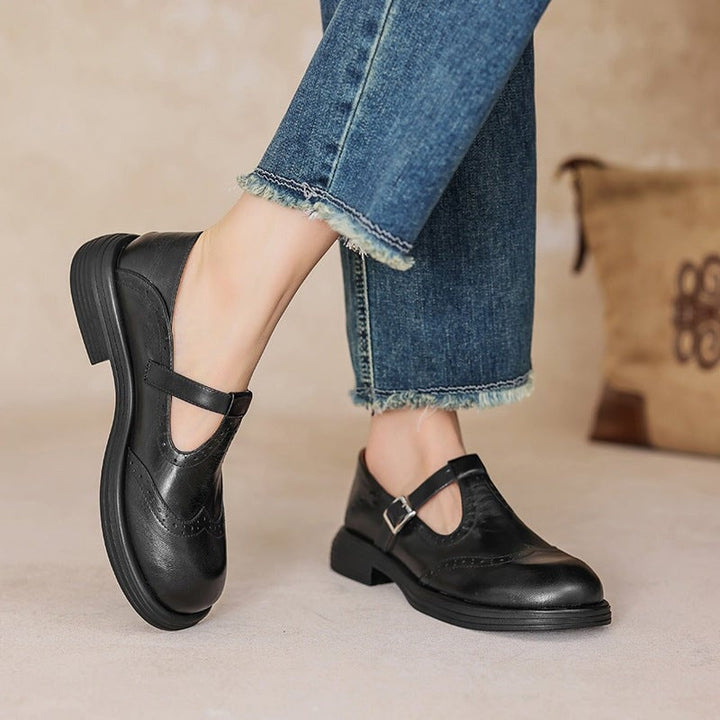 Nina sandal in black worn on foot showing elegant strap and low profile sole