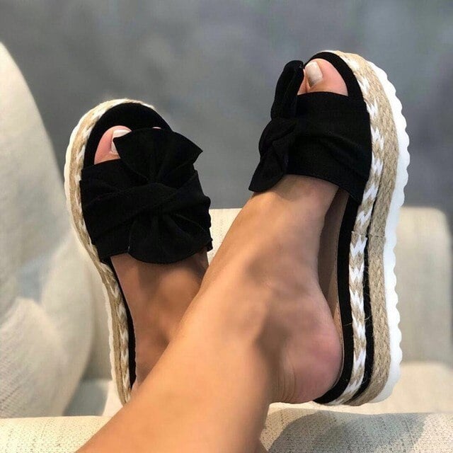 Close-up of Nina wedge sandal woven texture strap and bow detail