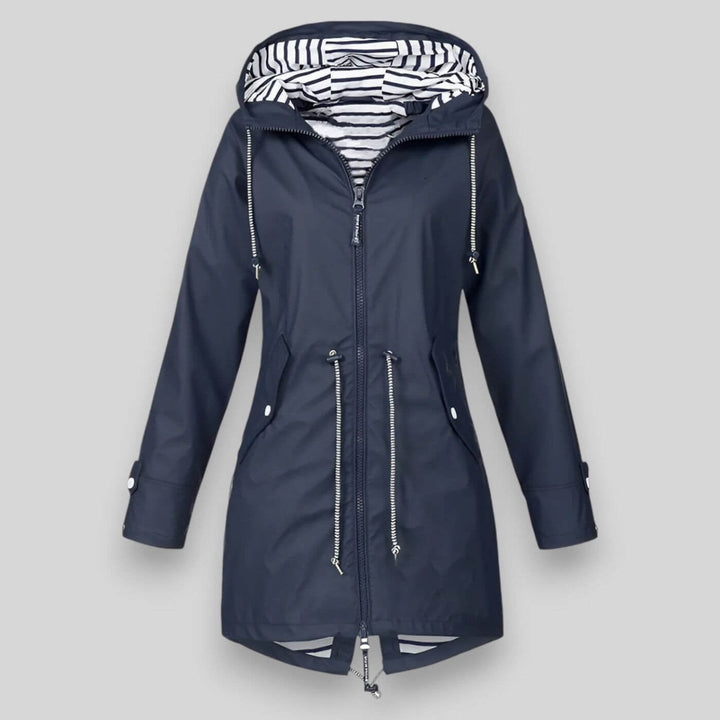 Woman wearing a sleek navy blue waterproof jacket with adjustable hood, styled for a rainy day