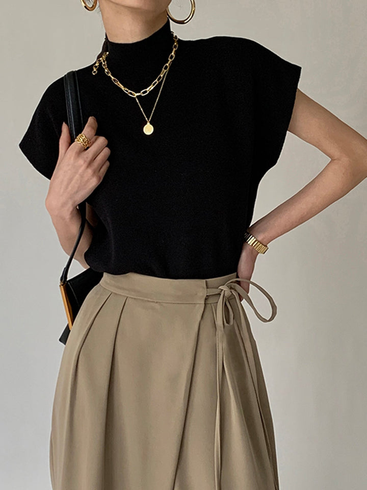 Front view of the Noira sleeveless mock neck knit top in black with padded shoulders