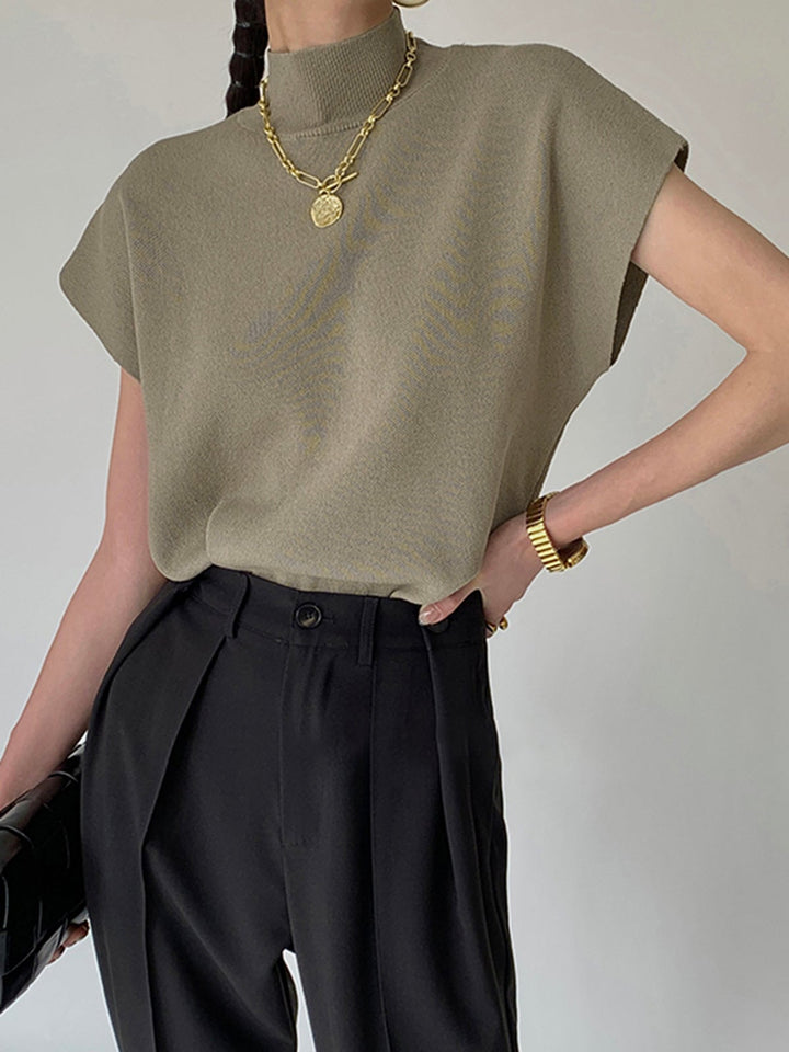 Front view of the Noira sleeveless mock neck top in off-white on model