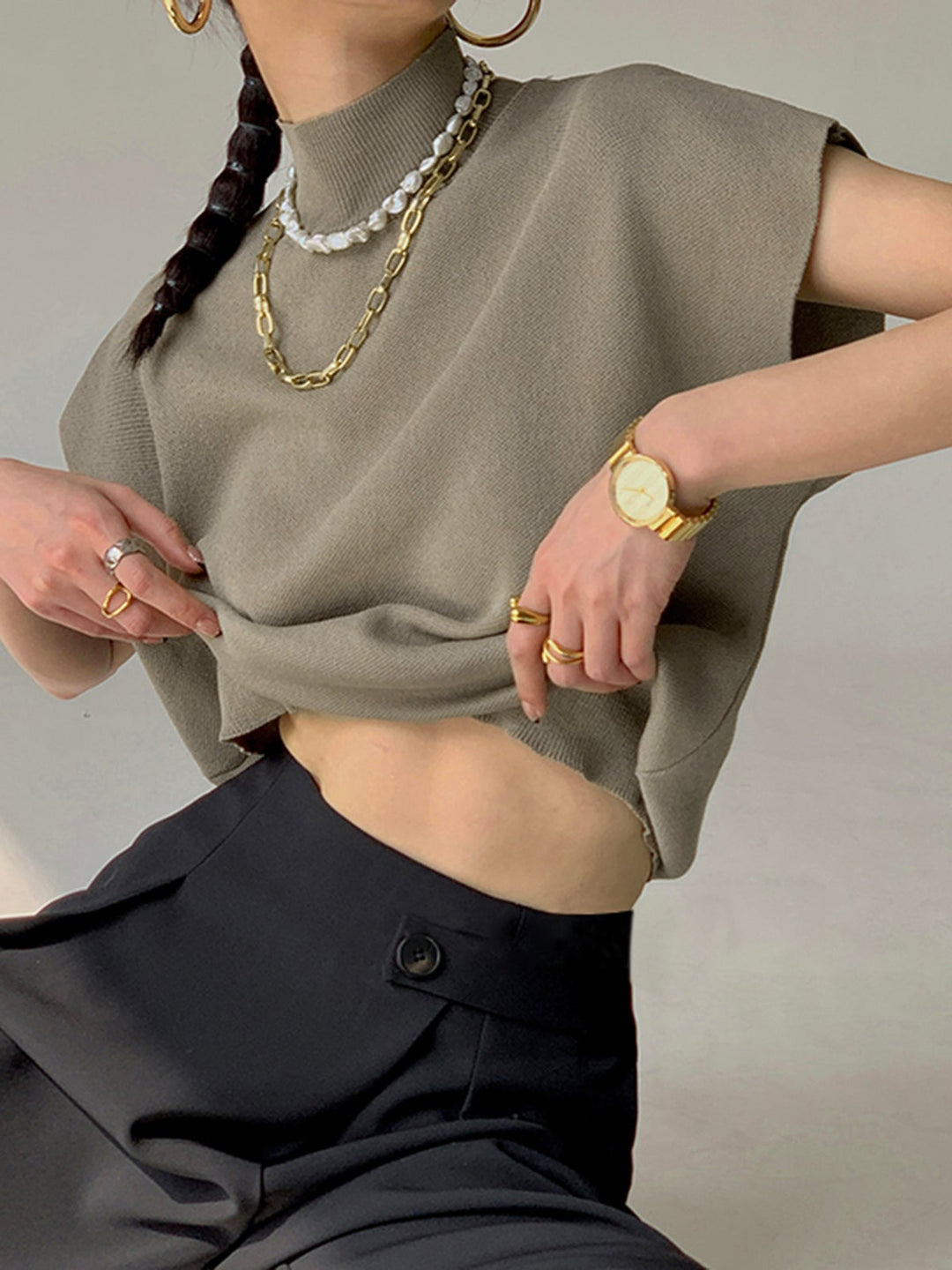 Model wearing the Noira top in off-white with tailored pants