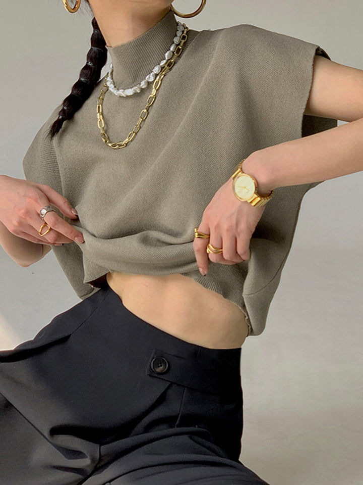 Model wearing the Noira top in off-white with tailored pants