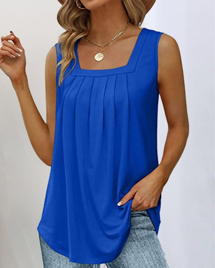 Model wearing a blue sleeveless top with square neckline in an outdoor setting
