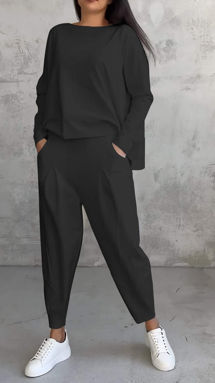 Back view of woman in the Nora off-white long-sleeve lounge set showing tapered pleated pant silhouette