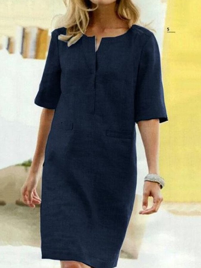 Woman styled in the Nora shift dress in Navy paired with low block heels for a smart-casual daytime look