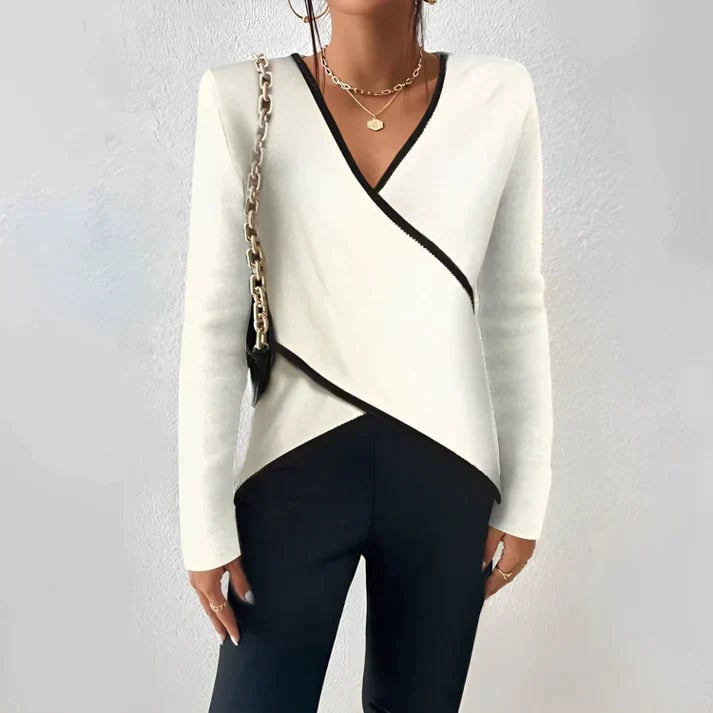 Florimay Nora ivory and black color block wrap blouse with deep V-neckline, asymmetric hem, and long fitted sleeves, worn by a woman