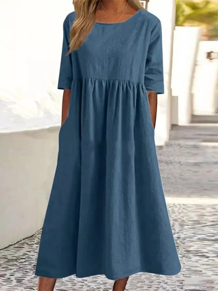 Woman wearing a breezy A-line spring dress in a soft neutral color, styled casually for daytime wear