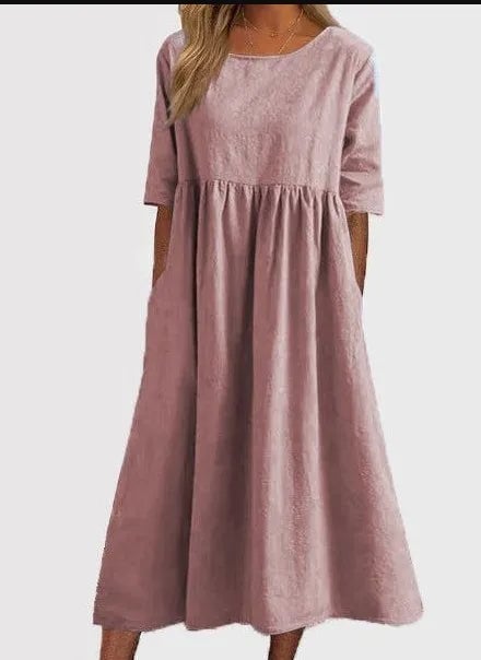 Woman in the Norah spring dress in white, standing outdoors in natural light