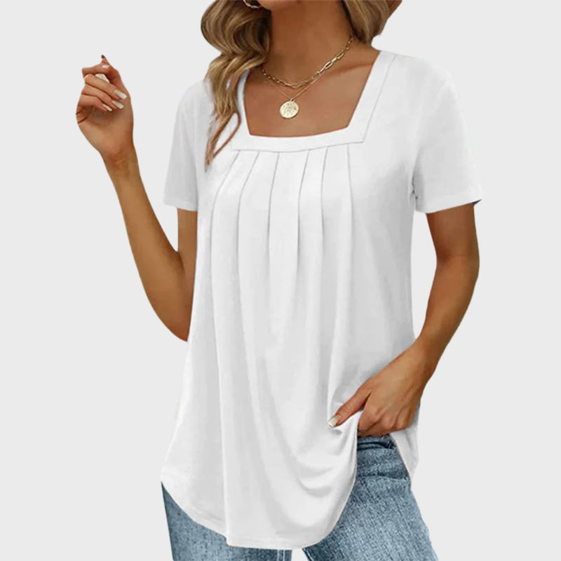Woman wearing a white airy square-neck summer blouse with front pleats and short sleeves