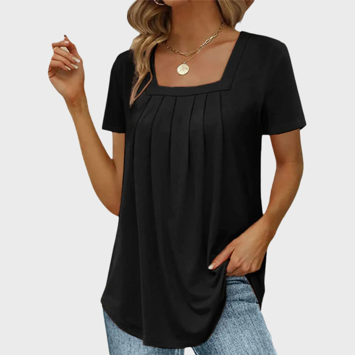 Woman in a dark green square-neck blouse styled with casual bottoms for a summer look