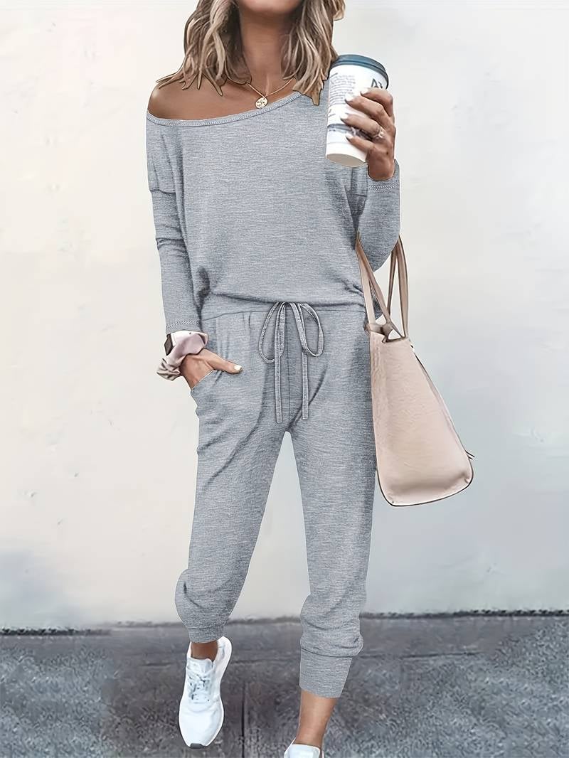 Woman wearing a grey off-shoulder top and matching drawstring jogger set in a relaxed casual style