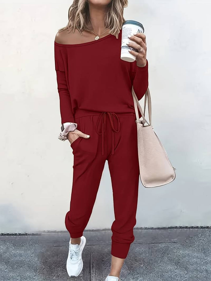 Full-length view of woman wearing the off-shoulder lounge set with drawstring joggers in a neutral setting